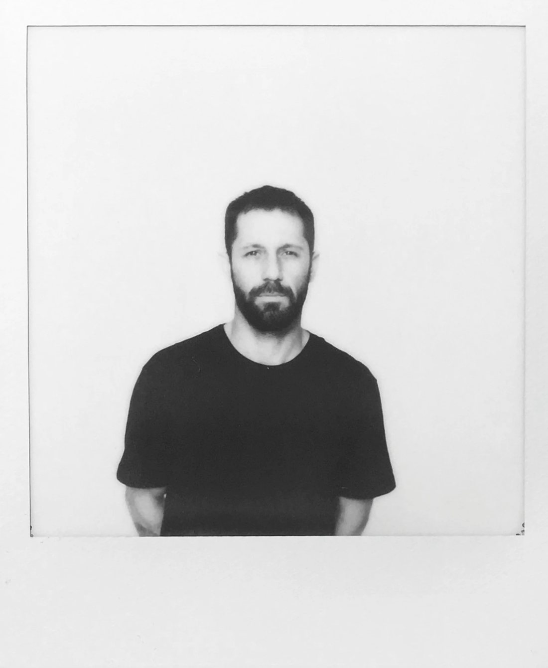 Louis Iruela, black and white instant photo portrait against a white wall
